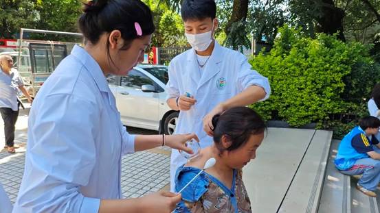 说明:1图为学生志愿者正在为社区居民拔罐.jpg